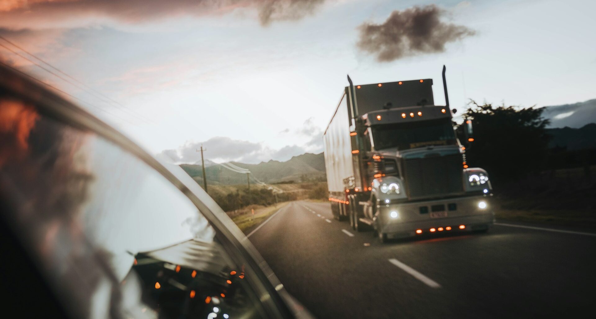 Tractor-trailer behind a car on a rural highway