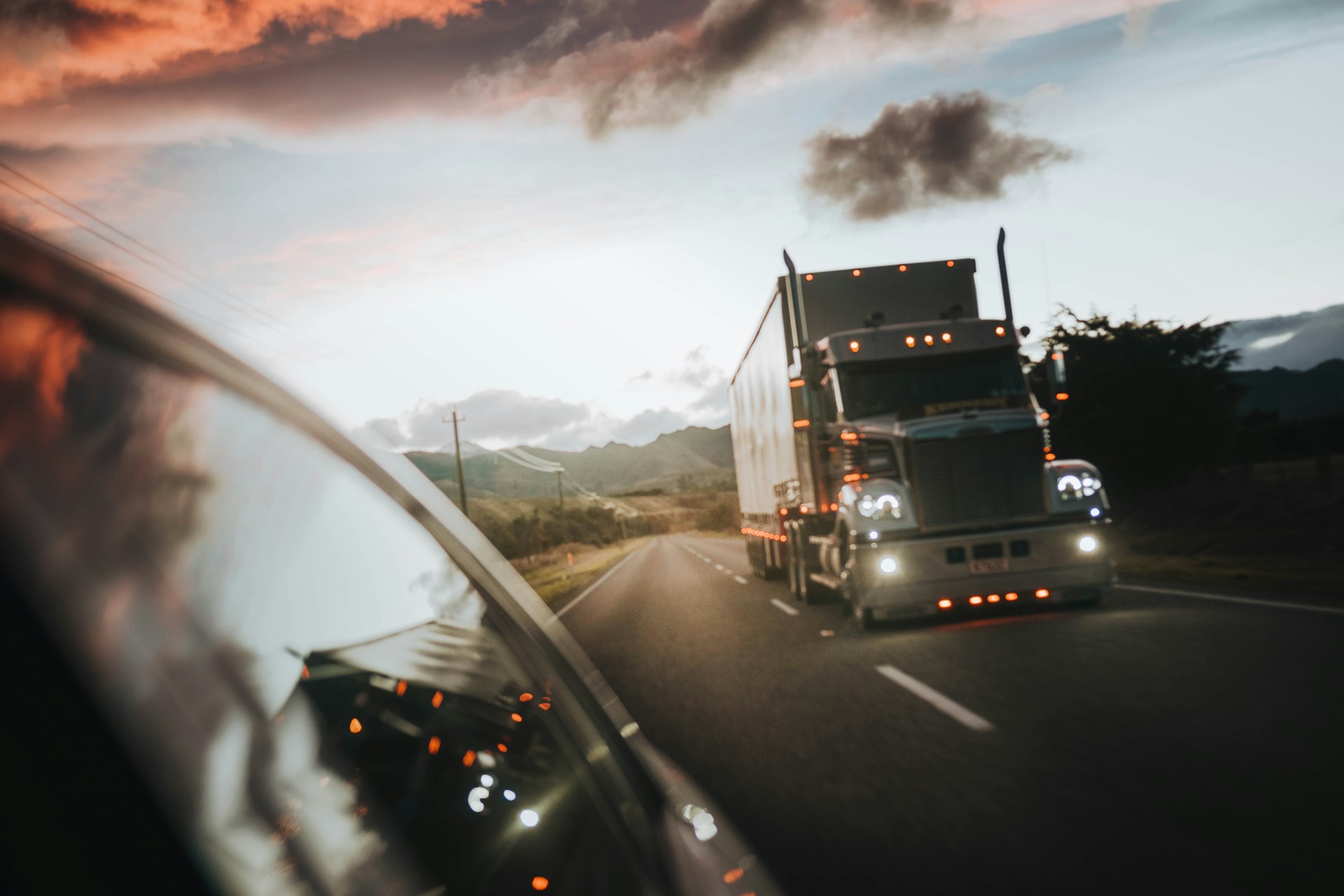 Tractor-trailer behind a car on a rural highway