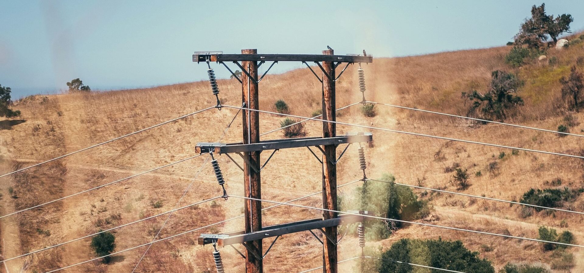 Utility company power lines on a hill full of dry brush
