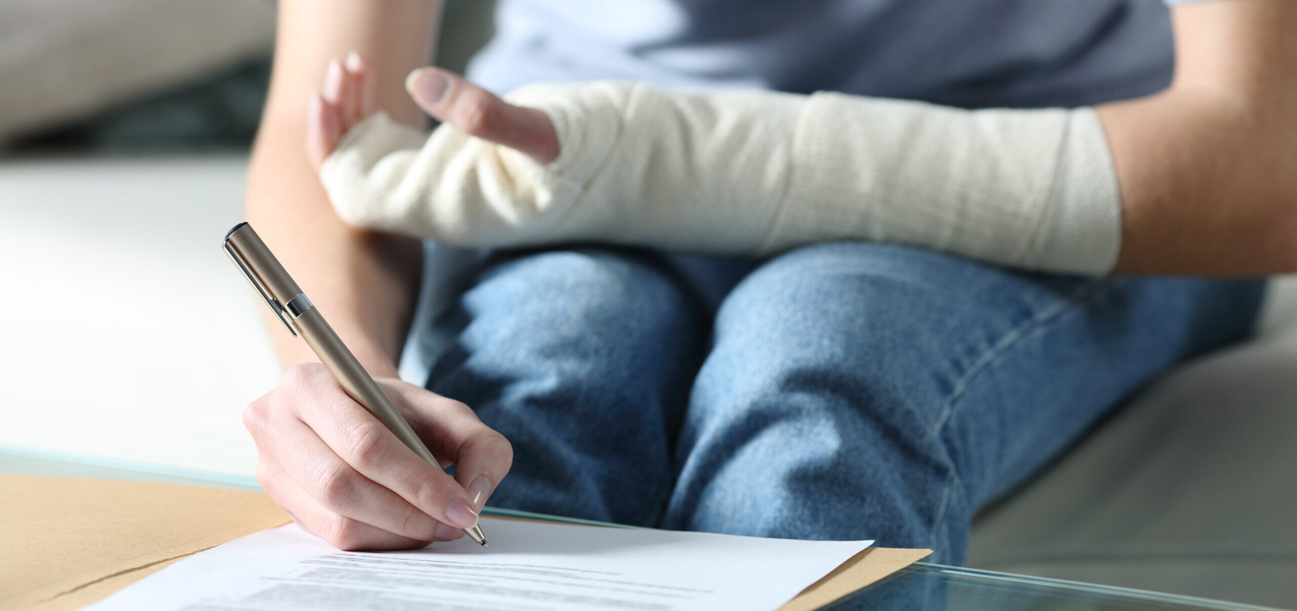 Person with injured arm signing a document