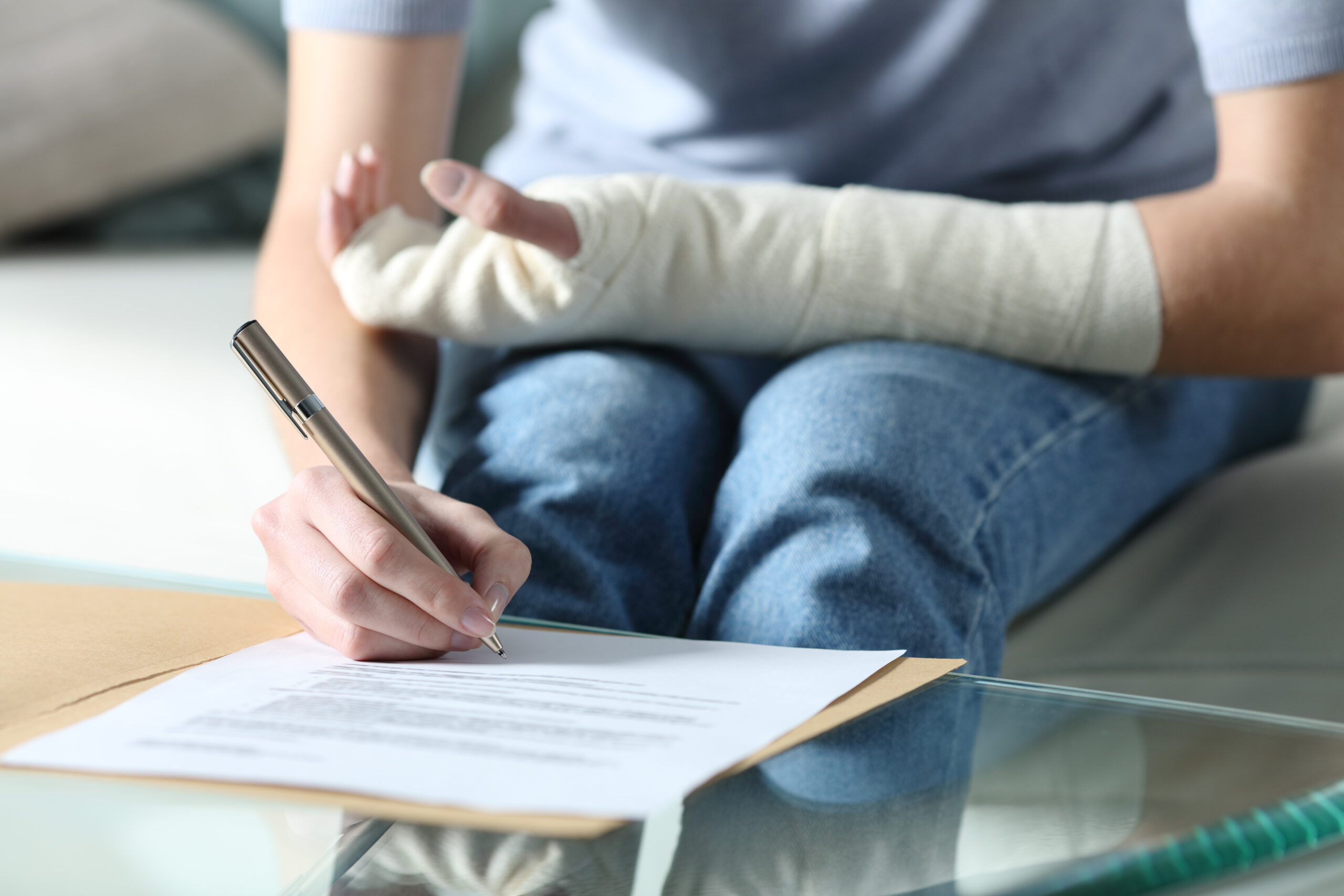 Person with injured arm signing a document