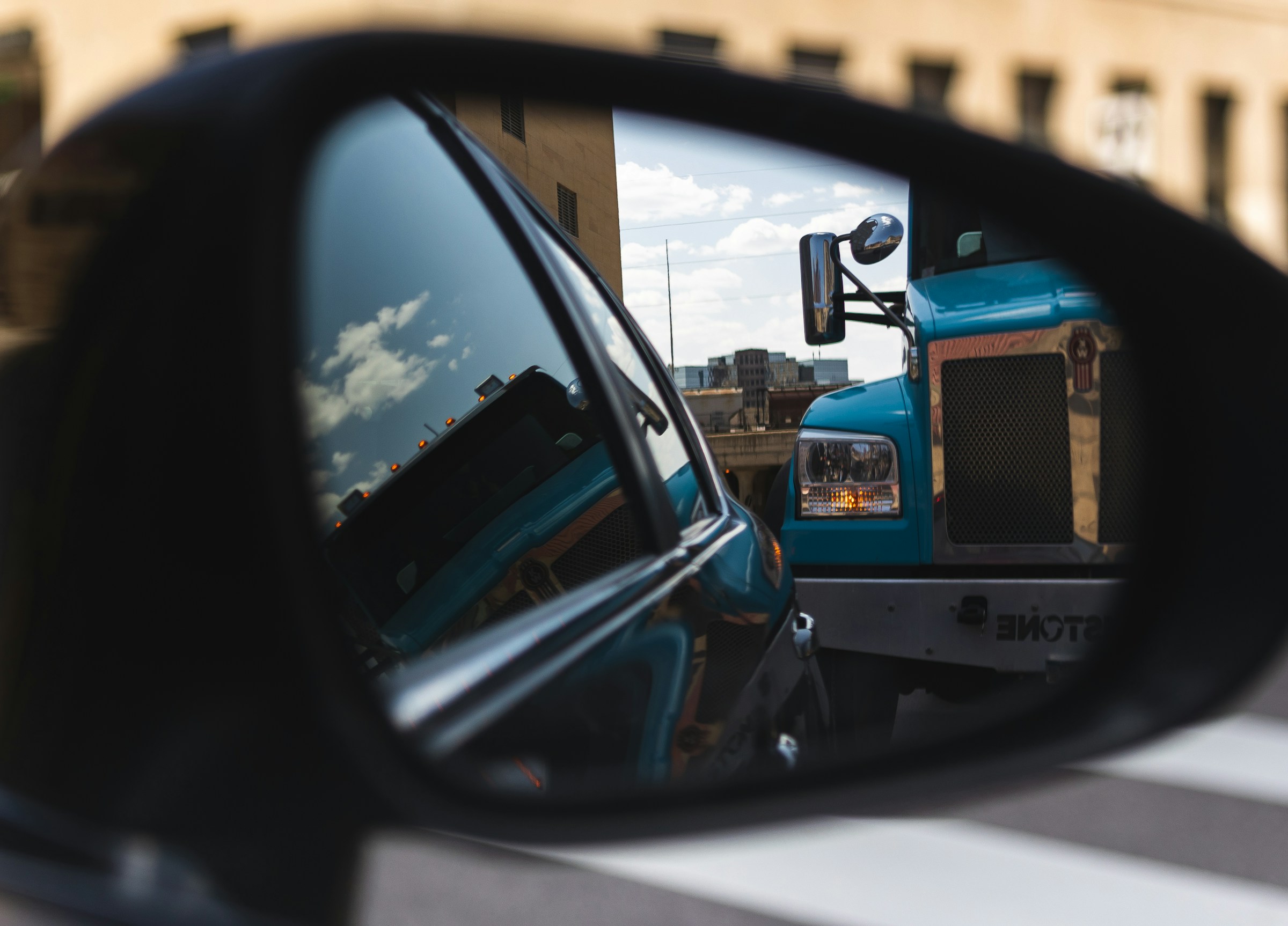 Large truck in the review mirror of a car