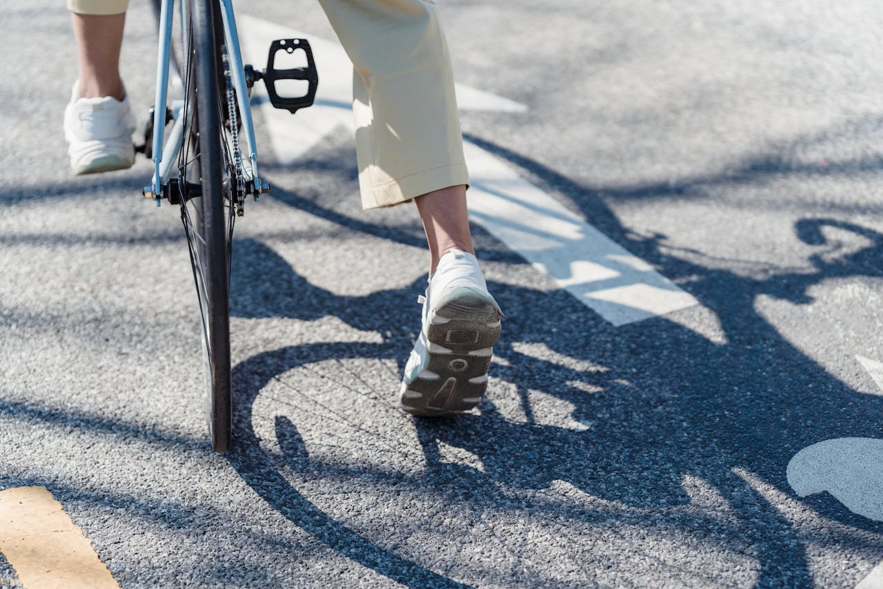 Bicyclist cautiously stopped, close up of feet, wheels, and road