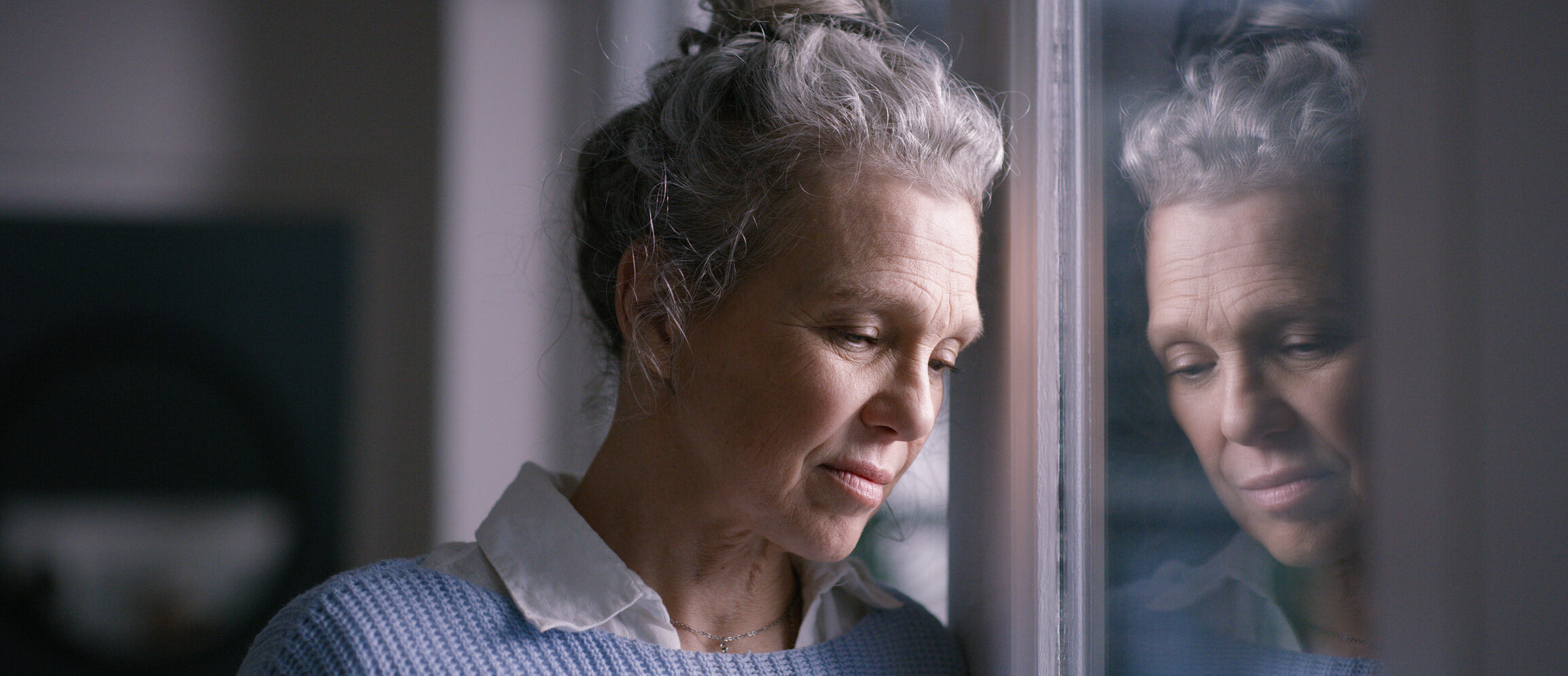 Depression, sad and senior woman by window looking, upset, lonely and unhappy in retirement home. Mental health, loneliness and and depressed elderly female thinking of problem, issues and crisis