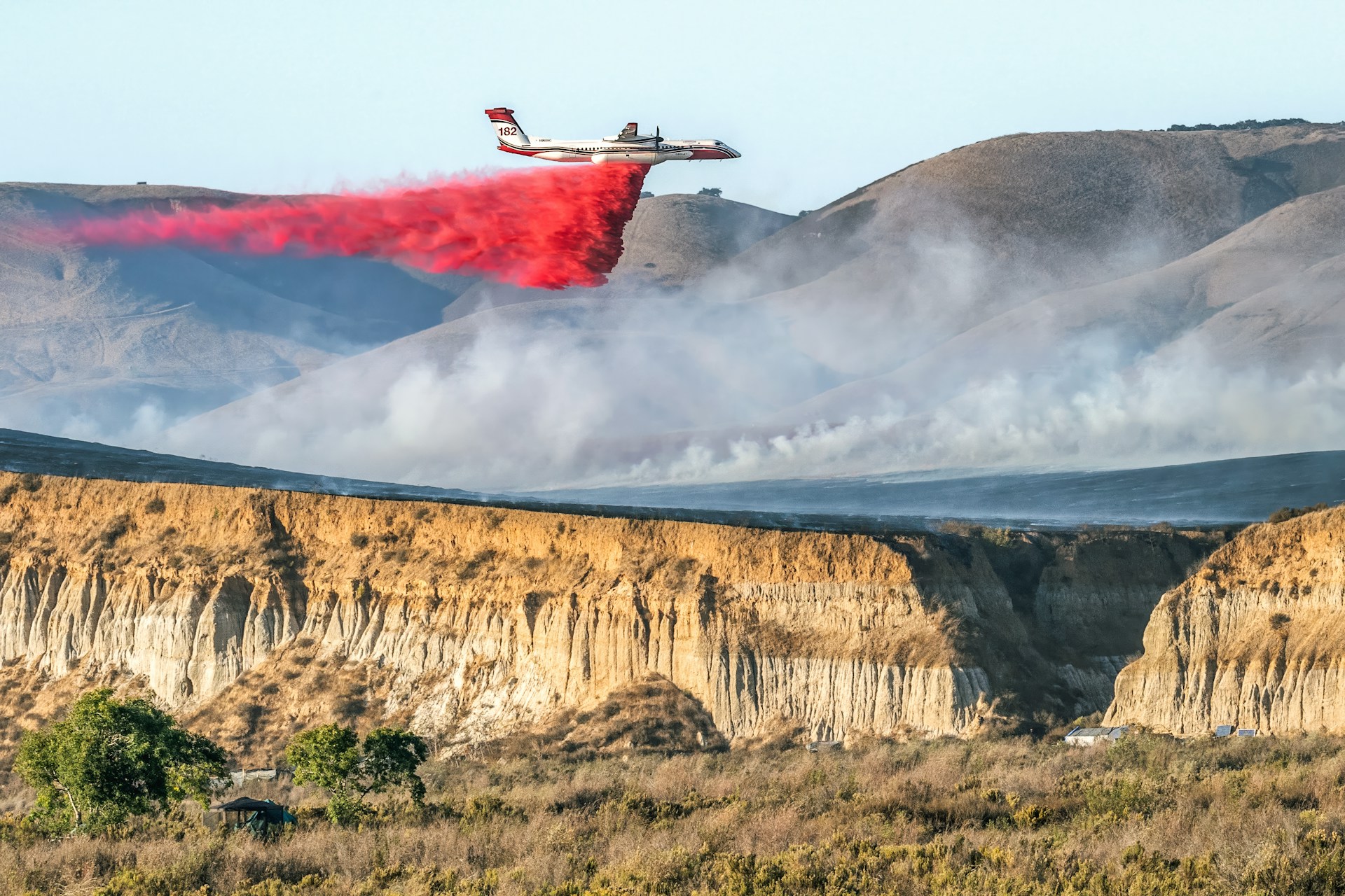 airtanker dropping fire retardant during a wildfire