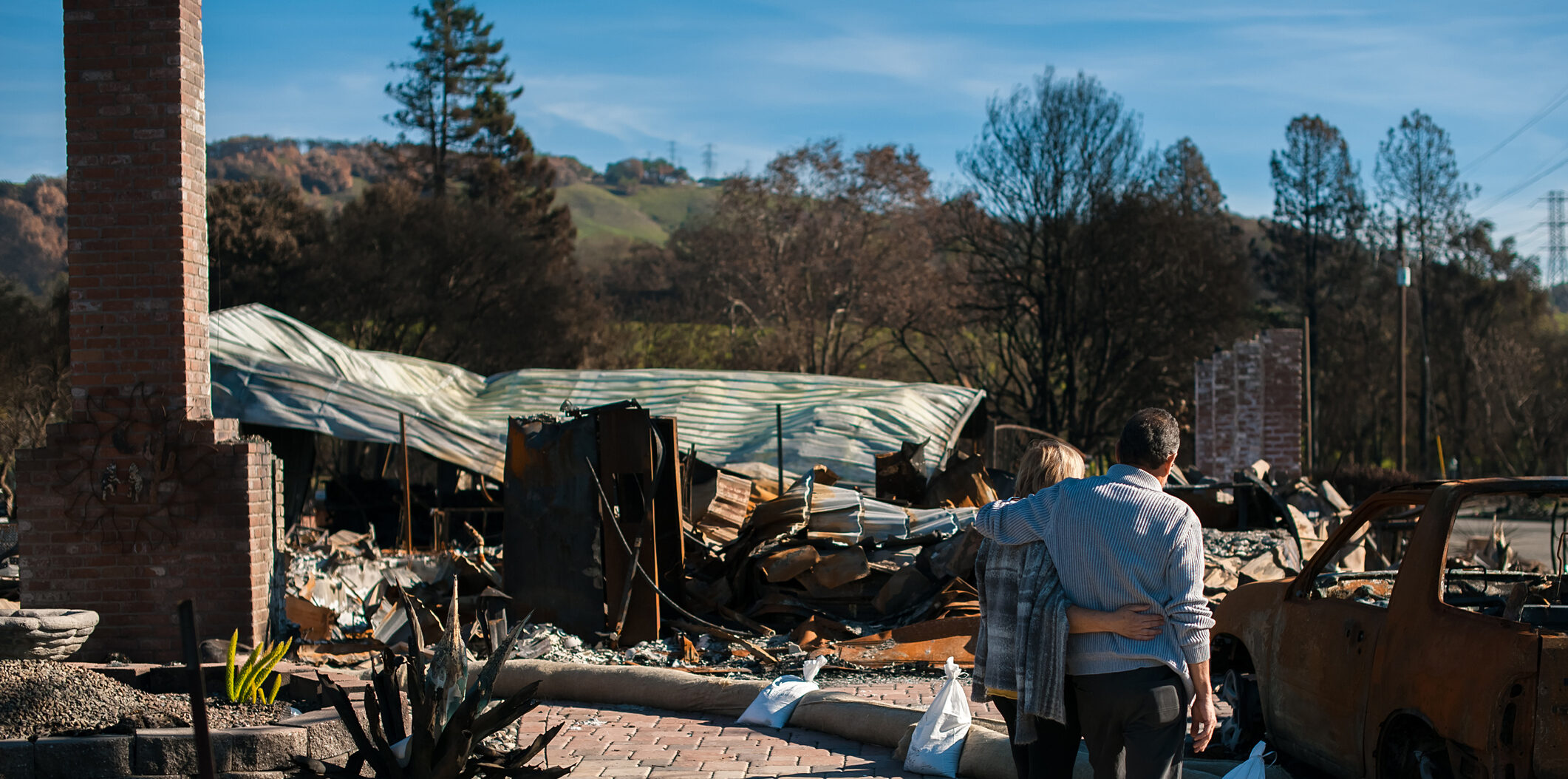 Man and his wife owners, checking burned and ruined house and yard after fire