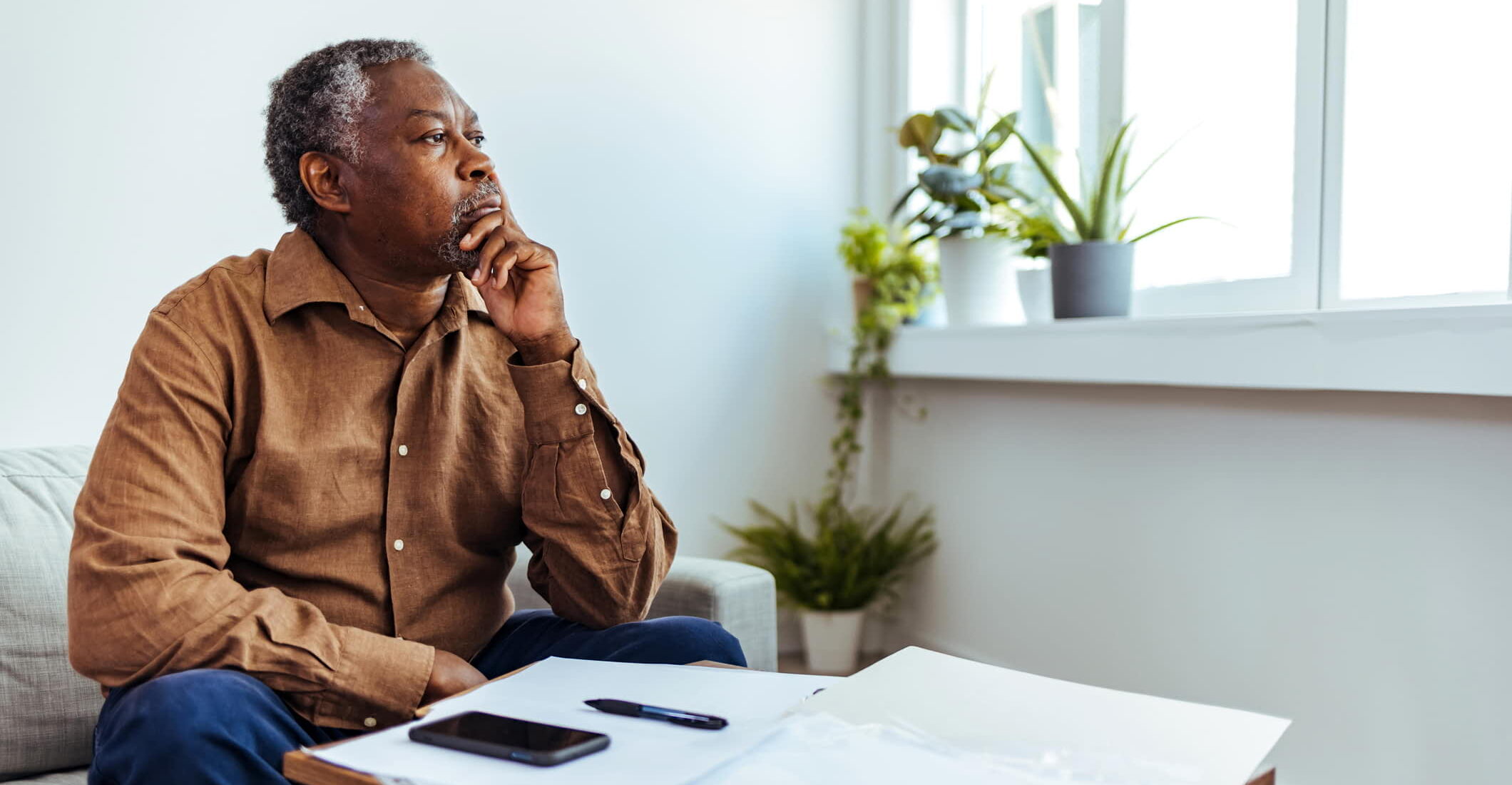 man doing insurance paperwork taking a moment to think