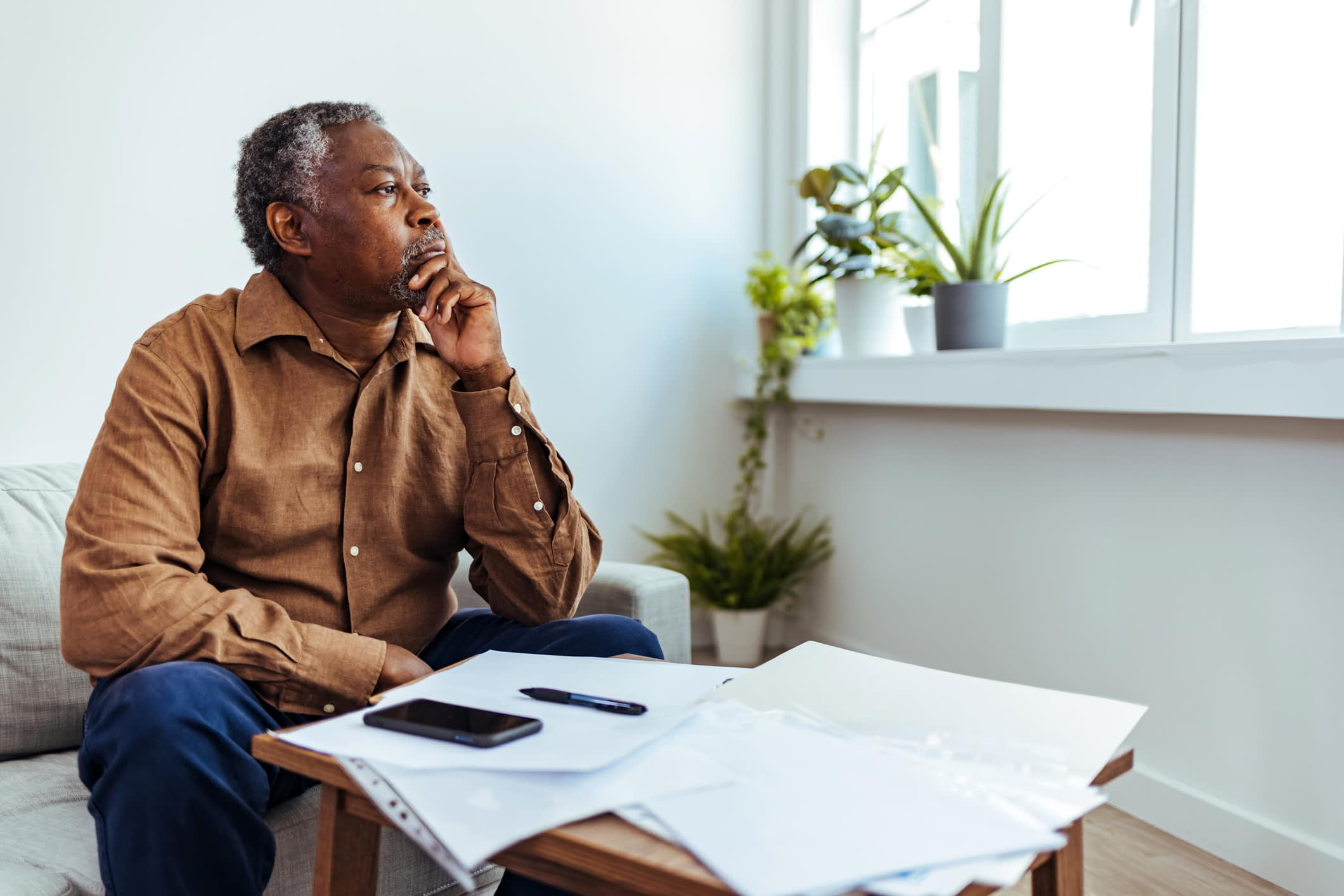 man doing insurance paperwork taking a moment to think