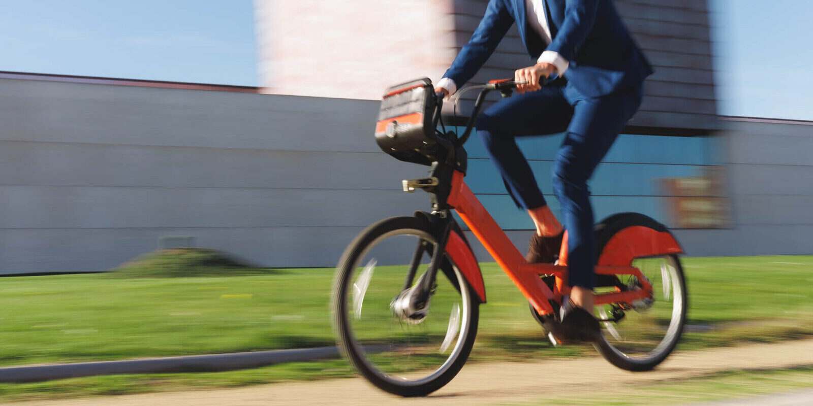 man in suit riding an e-bike fast