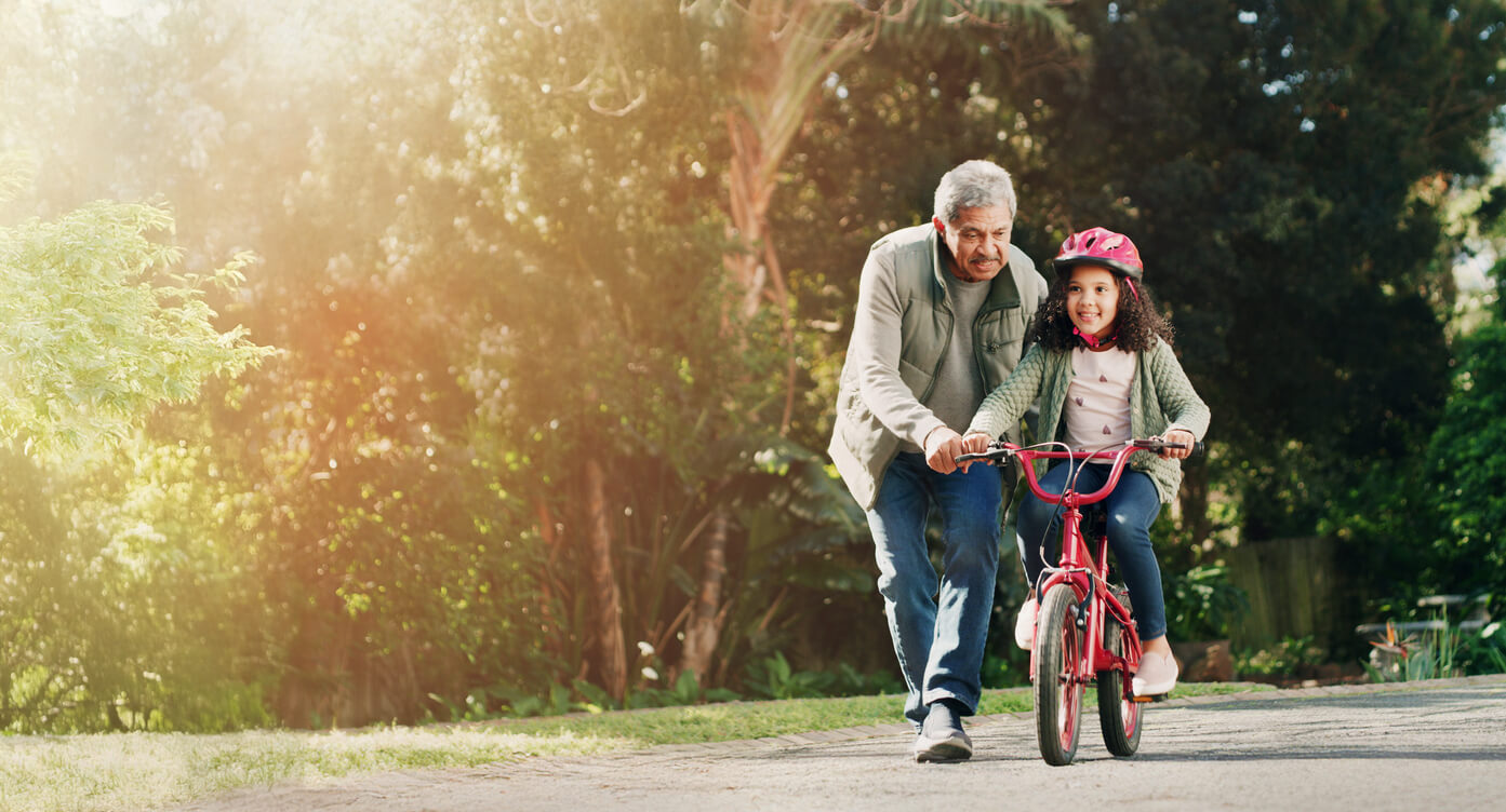 Grandparent teaching grandchild to ride a bike